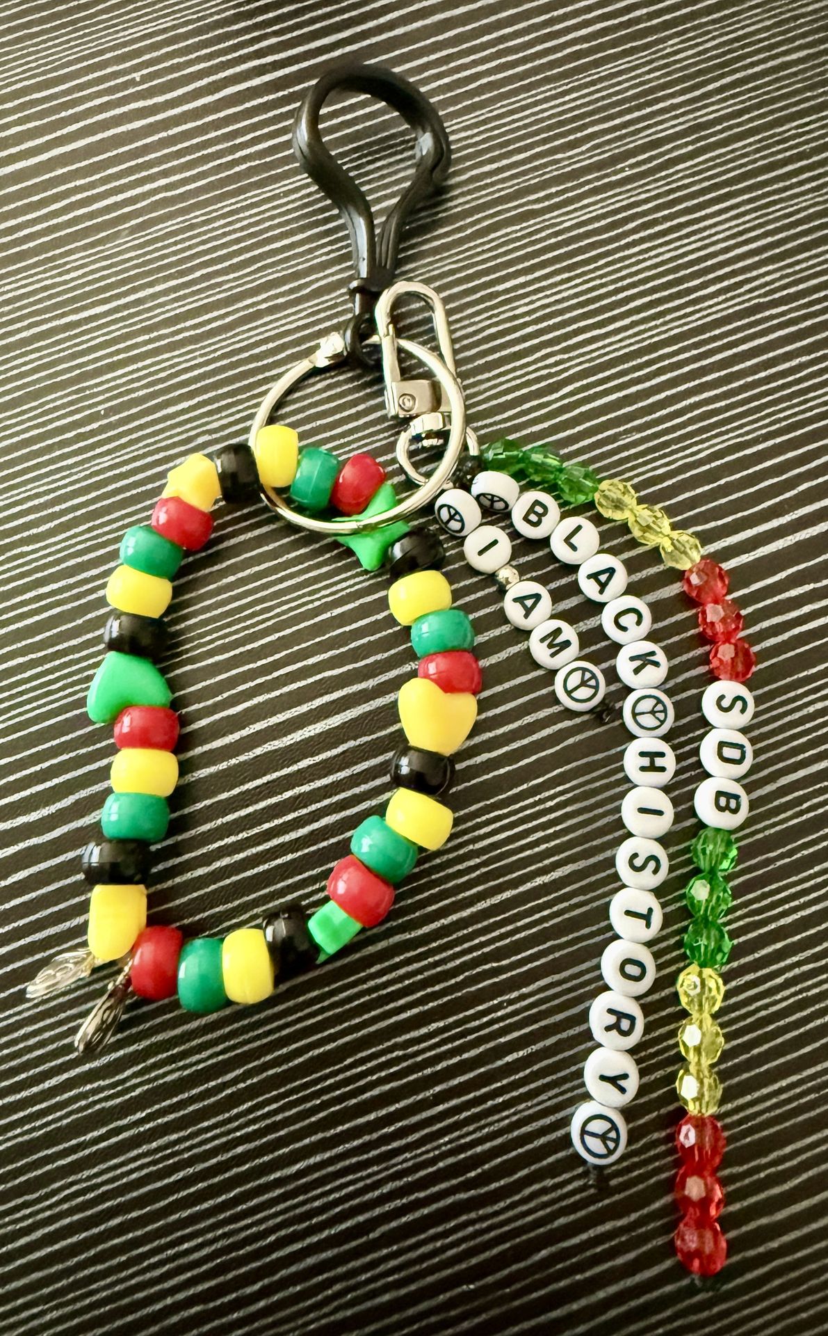 Colorful beaded bag charm with green, yellow, black, and red accents