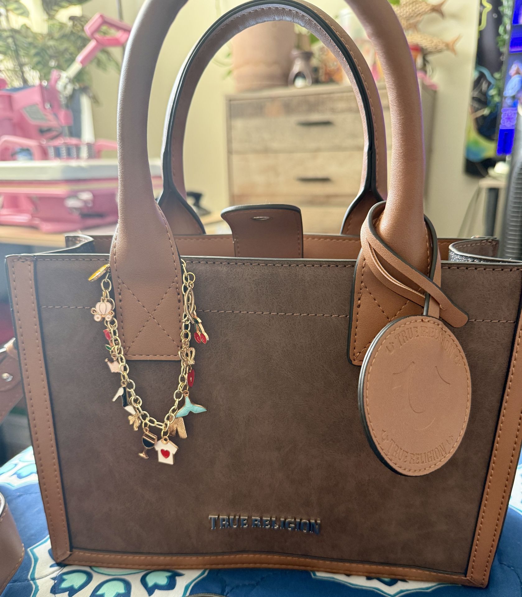 Brown True Religion handbag with dangling personalized bag charm