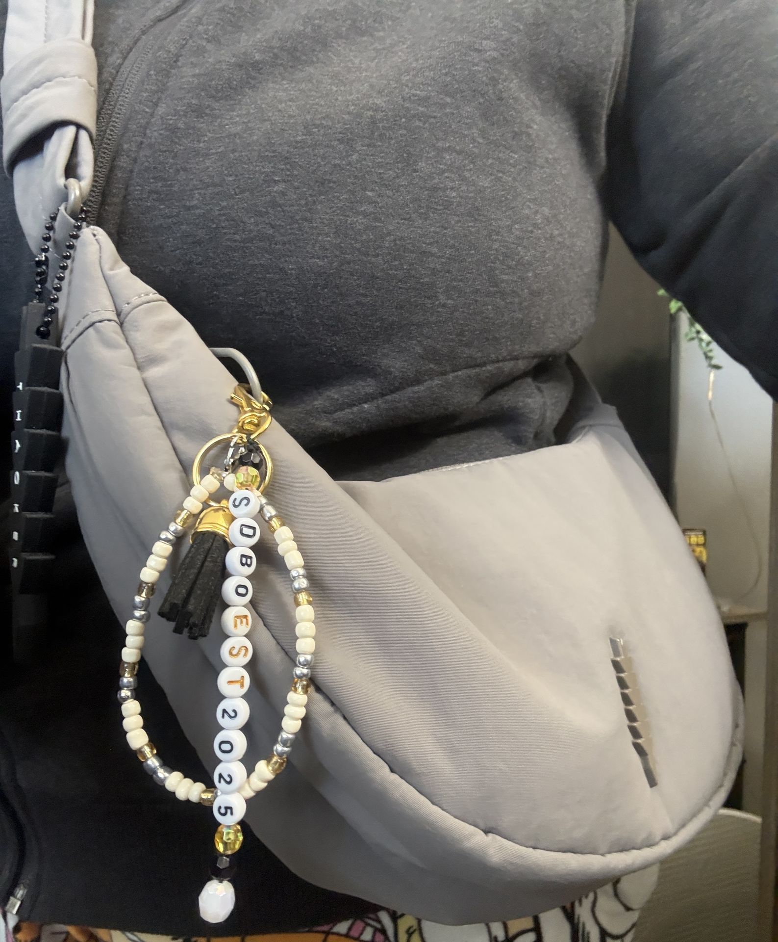 Neutral handbag decorated with a handmade beaded purse charm