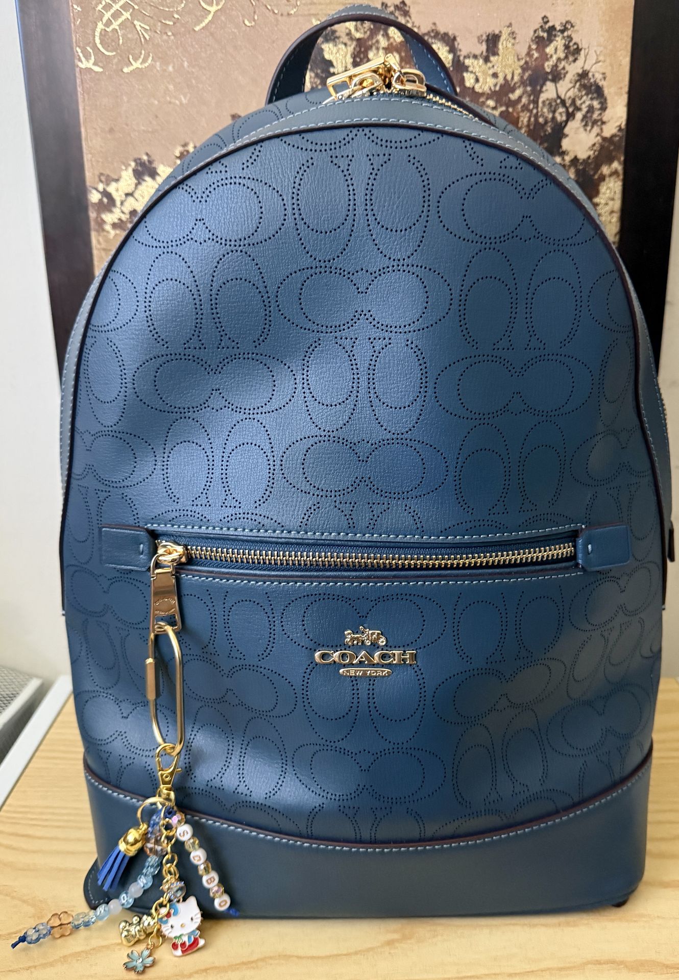 Blue Coach backpack with a personalized handmade bag charm